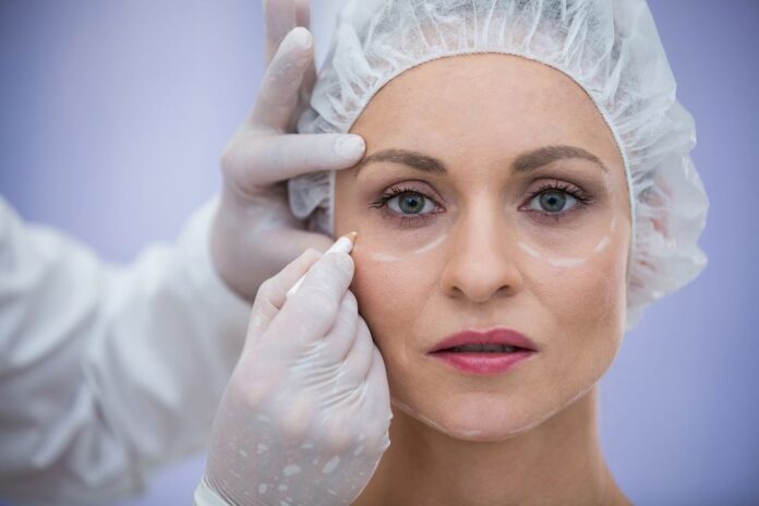 doctor-marking-female-patients-face-for-cosmetic-treatment