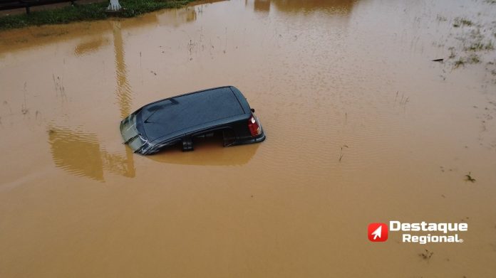 Carro parcialmente submerso em alagamento na Marginal da Via Anhanguera, em Cajamar, durante forte temporal na noite de sábado para domingo (25).