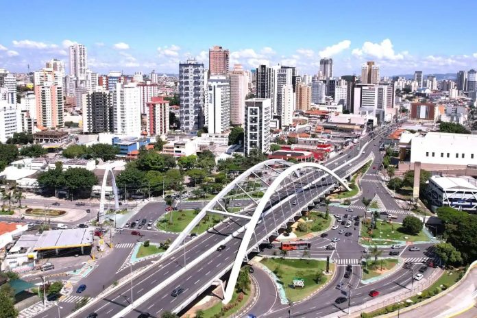 Vista aérea de Osasco com áreas urbanas, avenidas movimentadas e vegetação em dia ensolarado