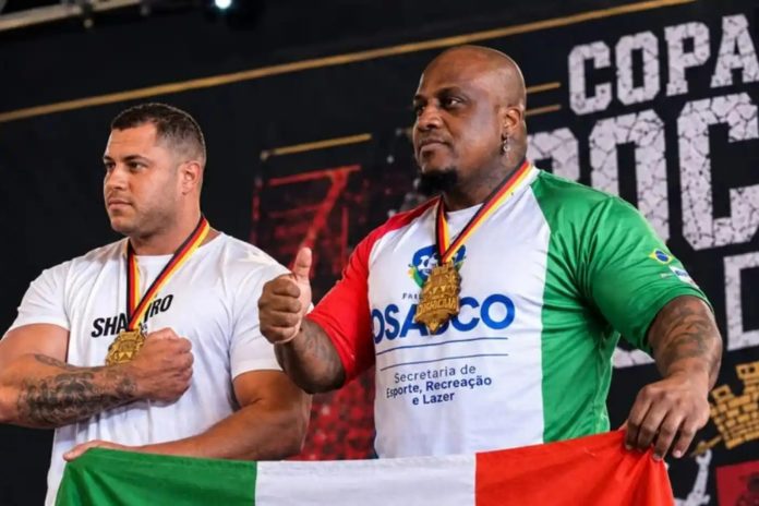 Adriano Mutante durante competição de supino em Sorocaba, com medalha de primeiro lugar e camiseta da Secretaria de Esporte, Recreação e Lazer de Osasco