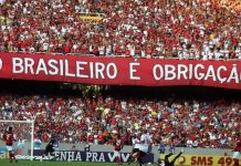 Brasileirão se torna prioridade máxima para o Flamengo após eliminações em outras competições Torcida do Flamengo exibe faixa com a frase "Brasileirão é obrigação" durante jogo, simbolizando a pressão e expectativa quanto ao título nacional.