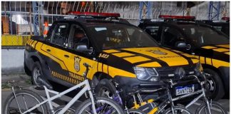 Barueri reforça fiscalização contra prática proibida de ‘pegar rabeira’ com aplicação de multa Bicicletas recolhidas em operação de fiscalização contra a prática proibida de 'pegar rabeira' em Barueri, com viaturas da Secretaria de Mobilidade Urbana ao fundo