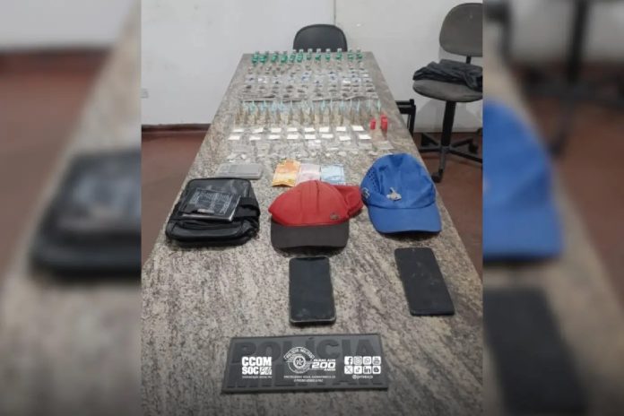Itens apreendidos pela Polícia Militar em operação no Parque Suburbano, Itapevi, incluindo drogas, dinheiro, celulares e objetos relacionados ao tráfico de entorpecentes.