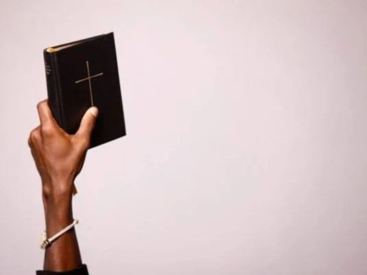 Justiça mantém demissão por justa causa de trabalhador que apresentou 88 atestados e atuou como pastor Pessoa segurando uma Bíblia durante culto religioso