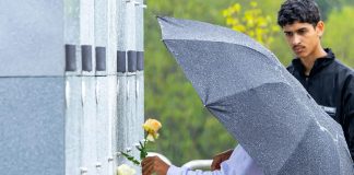 Itapevi promove atividades e transporte gratuito em cemitérios no Dia de Finados Visitantes realizam homenagem no cemitério municipal sob chuva, protegidos por guarda-chuva