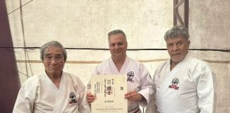 Gilberto Schavareto Jr. é homenageado internacionalmente com título honorífico em karatê Gilberto de Mello Schavareto Junior, técnico de karatê de Osasco, segurando o certificado do título Renshi Shihan concedido pela IKGA, ao lado de dois mestres durante a cerimônia em Cartagena, Colômbia.