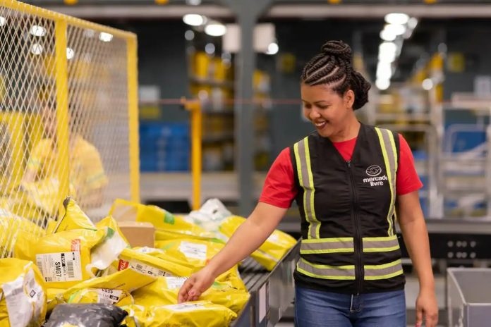 Funcionária do Mercado Livre em ambiente logístico manuseia encomendas amarelas em unidade operacional.