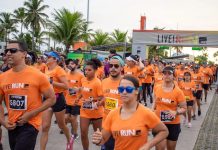 Circuito Nacional LIVE! RUN XP 2026 Chega a Barueri com Corridas e Atividades no Shopping Tamboré Participantes da LIVE! RUN XP usando camisetas laranja durante corrida, com faixa de largada ao fundo exibindo logo do evento